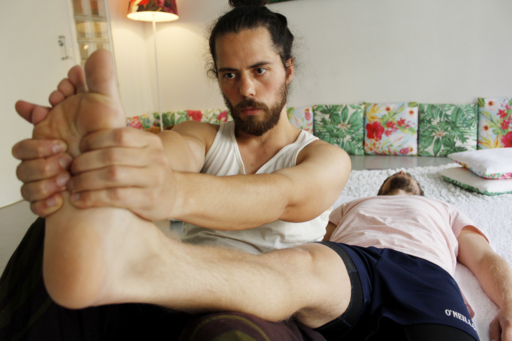 Thaihieroja hieroo vastaanottajan jalkapohjaa ja venyttää samalla tämän pohjetta.